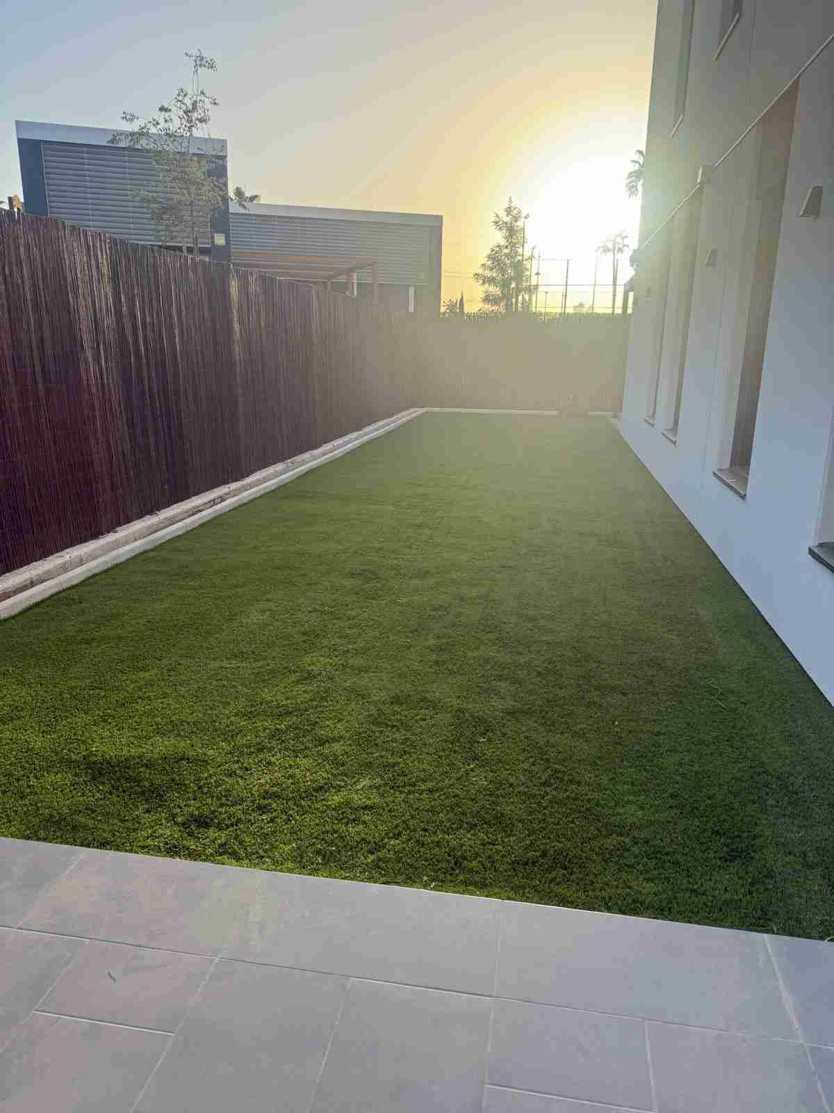 Área de piscina con césped artificial rodeando el borde